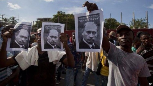 Haiti Protestors holding signs that read "Vladimir Putin, Please Help Us!"
