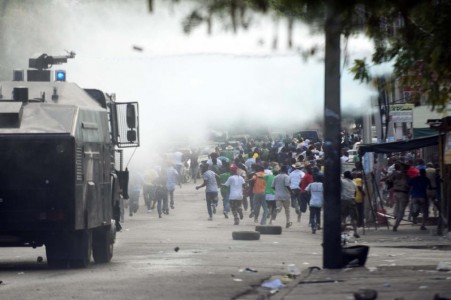 Demonstrators flee from a water cannon during a march against the government of Haitian President Michel Martelly in Port-au-Prince on January 10, 2015 (AFP Photo/Hector Retamal) 