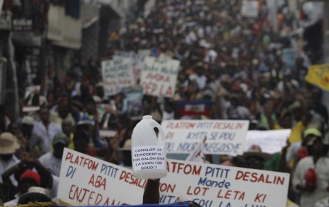 Demonstrators hold up signs with anti-government slogans during a protest in Port-au-Prince, Haiti, Saturday, Feb. 7, 2015. Several thousand protesters marched through Haiti's capital to demand lower gas prices and the ouster of President Michel Martelly. ( AP Photo/Dieu Nalio Chery)